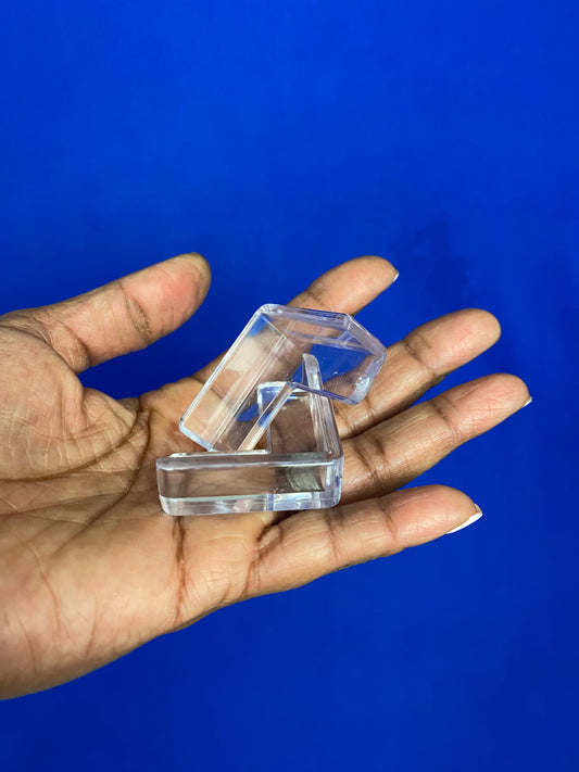 A hand displaying two clear L shaped corner guards 